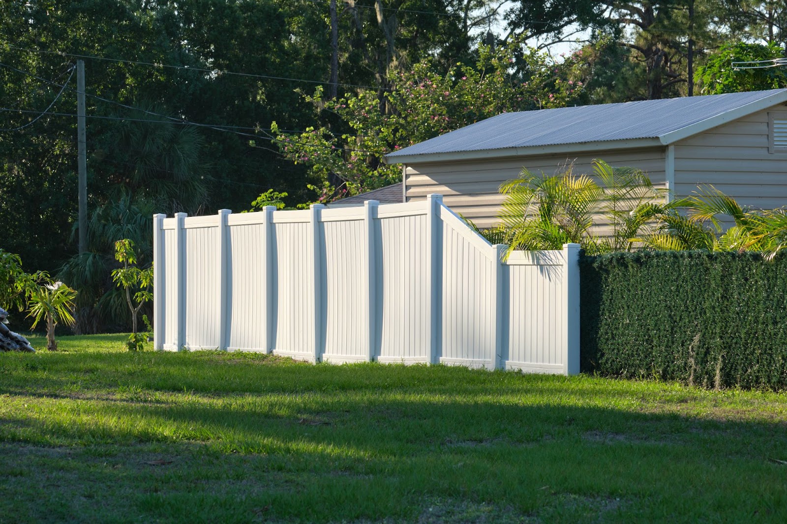 A backyard enclosed with white vinyl fence panels for safety and seclusion.