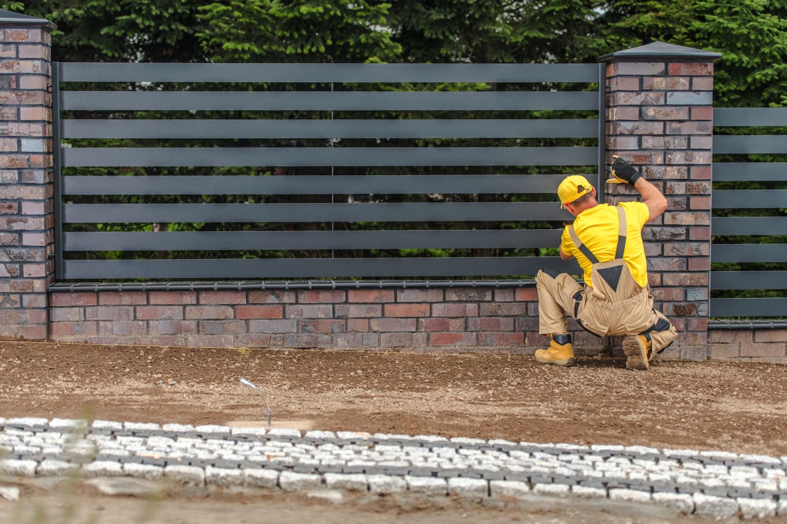 A worker is installing a modern fence.