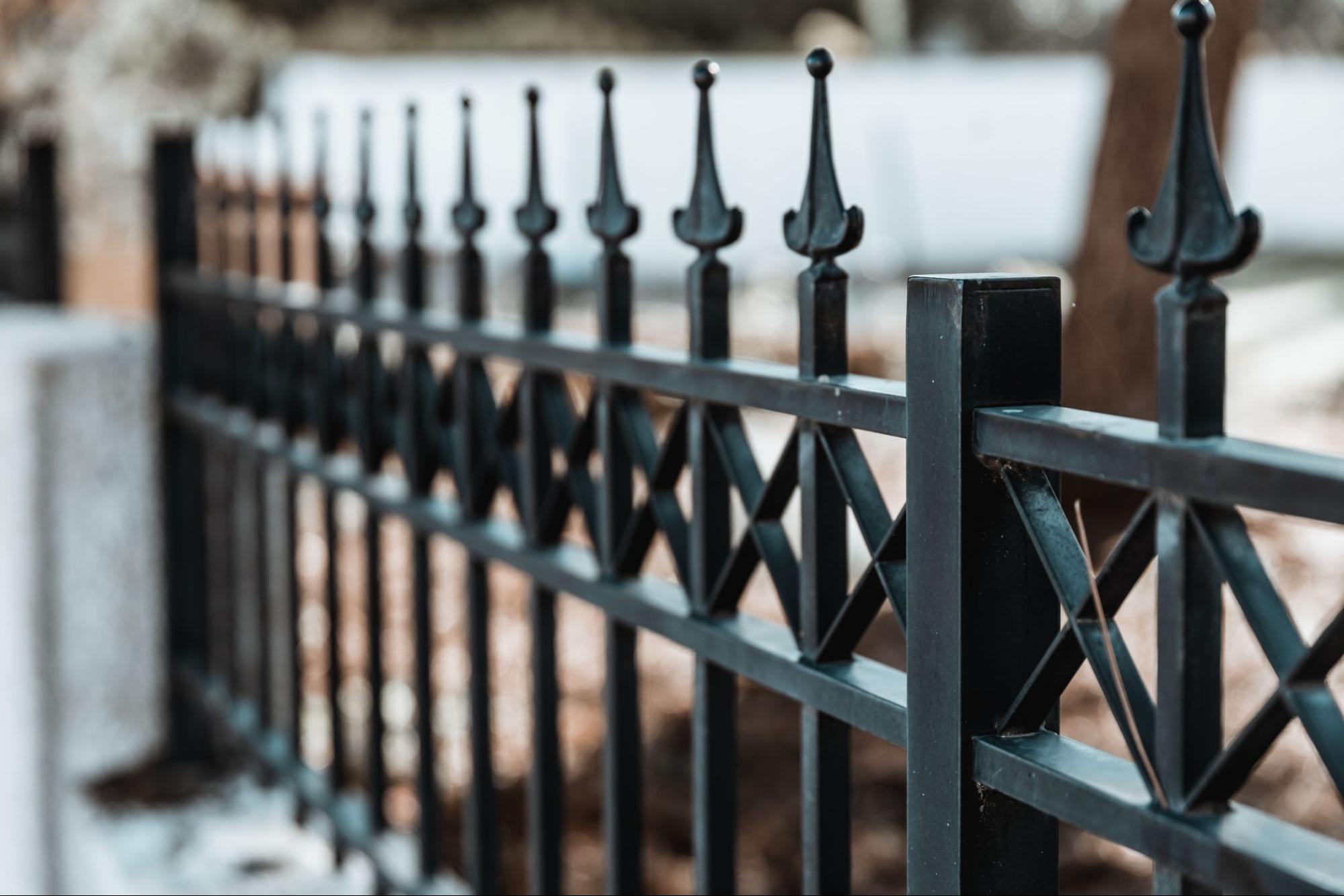 A close-up view of a modern vertical iron security fencing in matte black.