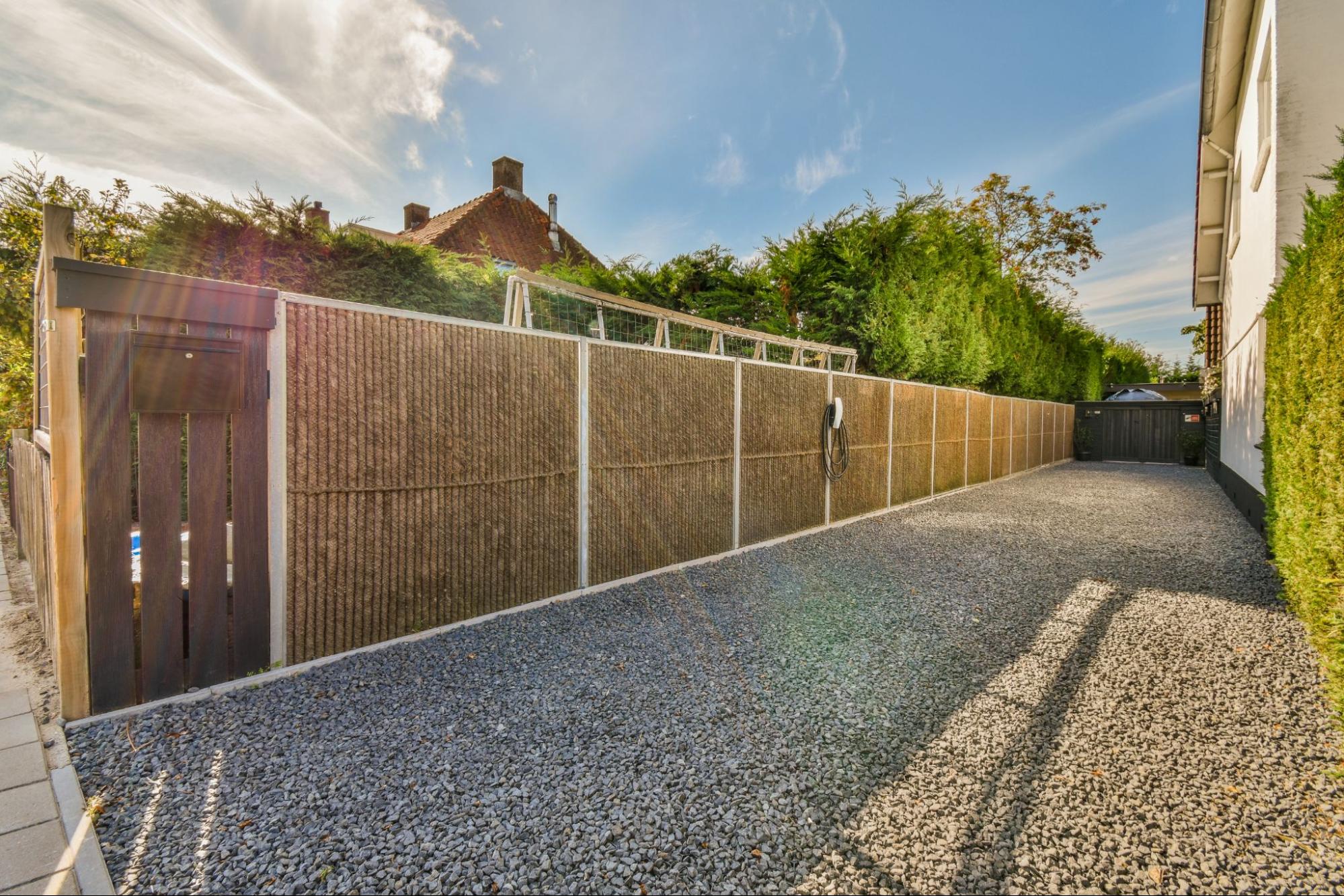 Custom bamboo fence with steel frames enclosing a large estate.
